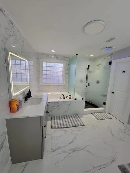 Completed shower and bath with tiled walls and glass screen