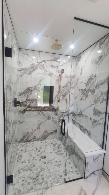 Completed shower in marble tile with a recessed niche