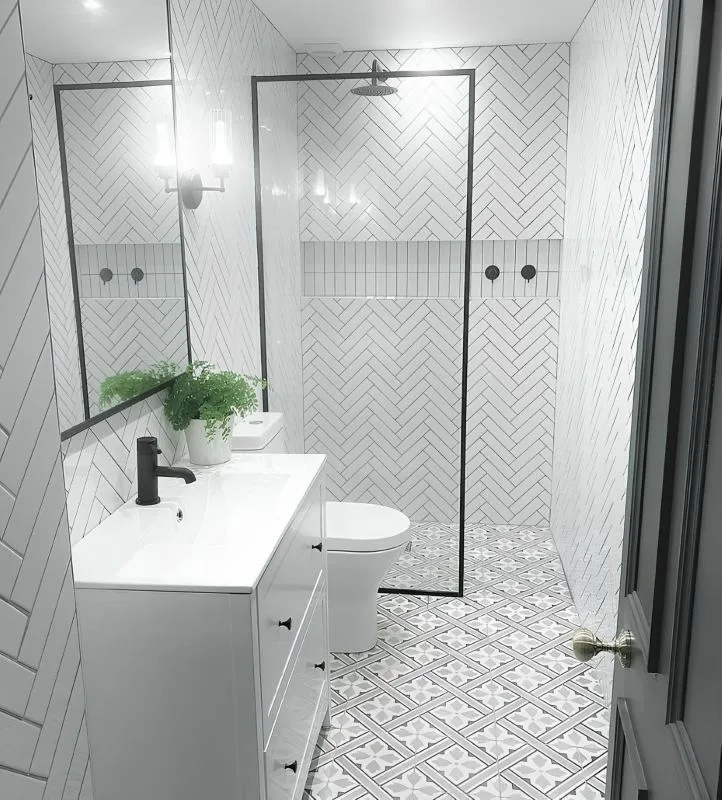 Bathroom with patterned tile flooring and herringbone wall tile