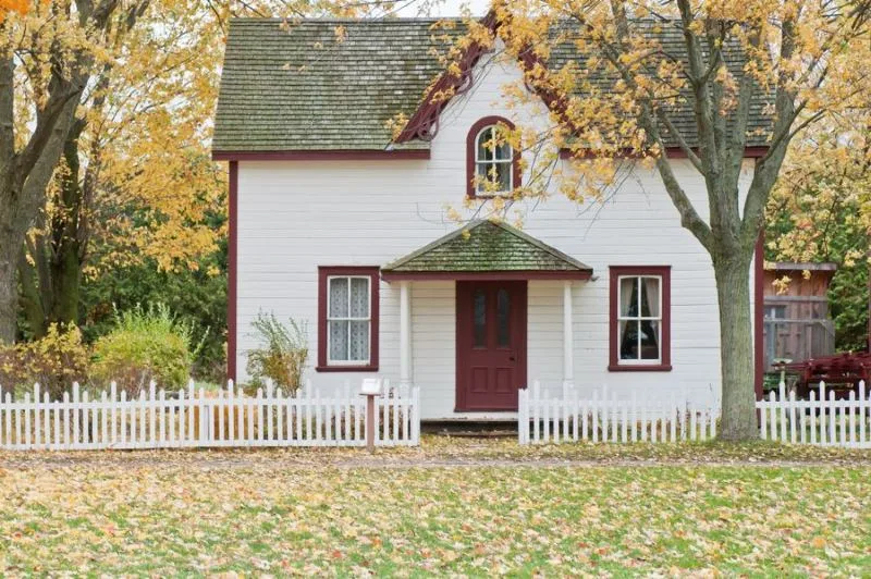 White picket fence in front of a timber clad house